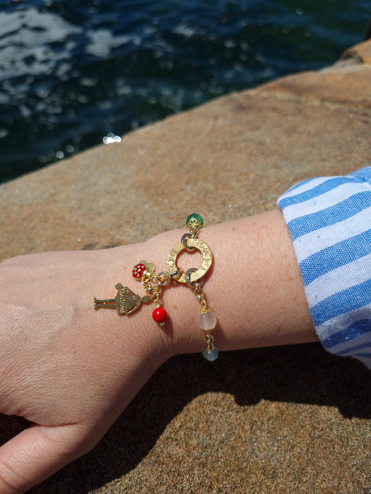 Girl wearing gold bracelet with charms.