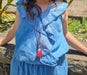 little girl in blue jumpsuit at a park wearing long doll chain necklace