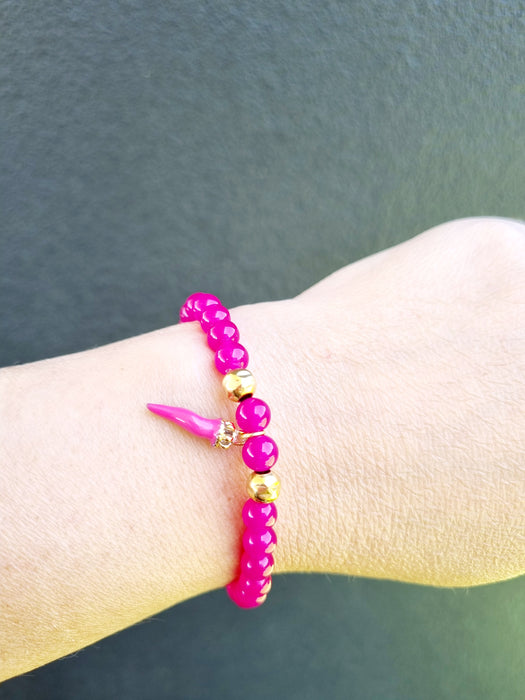 girl wearing hot pink bead bracelet with horn charm