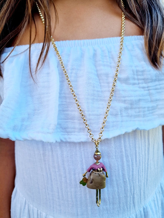 girl wearing gold long chain doll necklace