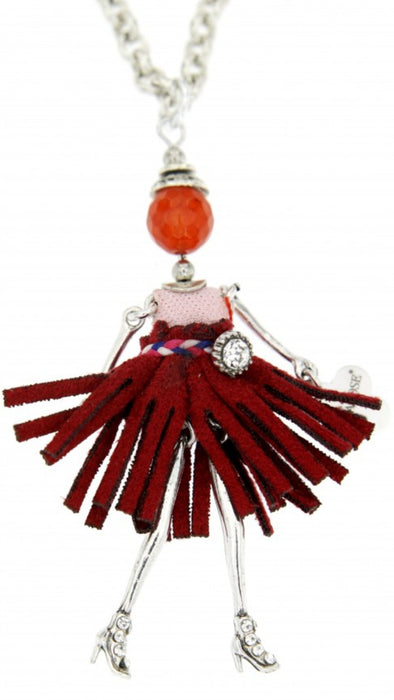 long chain silver necklace with doll pendant. doll is silver with maroon material skirt, belt with stone feature, pink top and orange head. doll charm has rhinestone like high heels